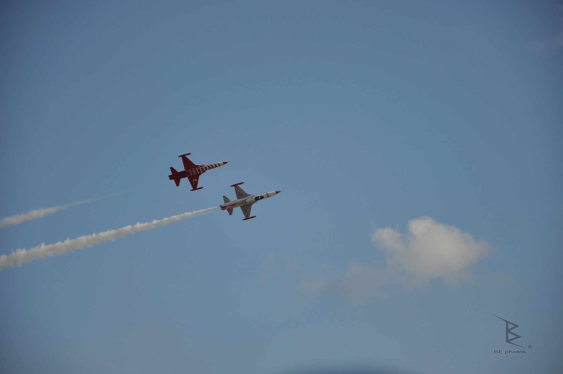 A Turkish Stars pair flying together with white smoke trails against a blue sky.